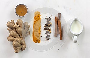 Ingredients for turmeric latte golden milk . Ground turmeric, curcuma, cinnamon, ginger, honey, peper, jug of milk over light