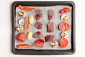 ingridients on the baking sheet: pepper, beef meat, tomatoes, mushrooms