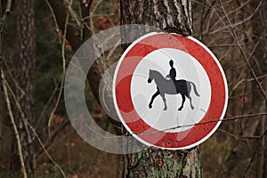 Ingrown traffic sign prohibiting thoroughfare of equestrians photo