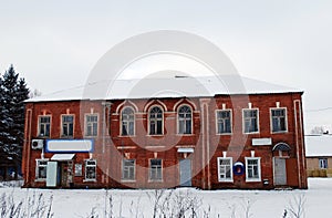 The inhabited old brick two-storeyed barrack with grocery stores on the first floor in the village of Karmanovo.