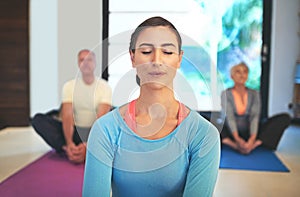 Inhale deeply, exhale slowly. a yoga instructor guiding a senior couple in a yoga class.