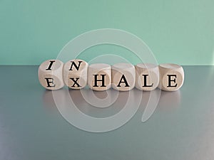 Inhale, Exhale concept. Turned a dice and changes the word INHALE to EXHALE.
