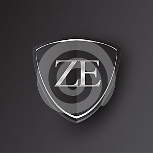 Initial logo letter ZE with shield Icon silver color isolated on black background, logotype design for company identity