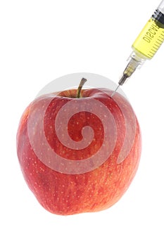 Injection into an apple. A hand in a medical glove with a syringe on a White background. Genetic modified foods. Injection of GMOs