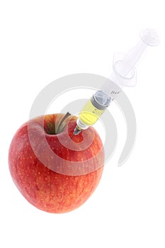 Injection into an apple. A hand in a medical glove with a syringe on a White background. Genetic modified foods. Injection of GMOs