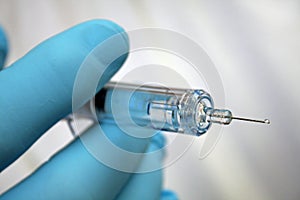 Injection needle held by gloved hand