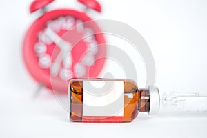 Injection vials and syringe on redclock background