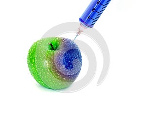Injection vibrant blue into red fresh wet apple with syringe on white background for renew energy , GMO or Synthetic or boost up