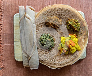 Injera with lentils and vegetables, sour fermented pancake-like flatbread which is a staple food of Ethiopia and Eritrea