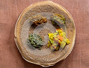 Injera with lentils and vegetables, sour fermented pancake-like flatbread which is a staple food of Ethiopia and Eritrea