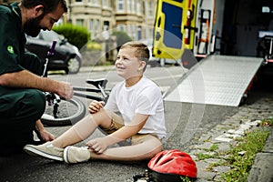 Injured boy getting help from paramedics photo