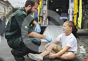 Injured boy getting help from paramedics photo