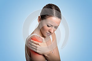 Injured joint. Woman patient in pain having painful shoulder colored in red. photo