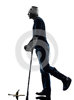 Injured man careless walking with crutches silhouette