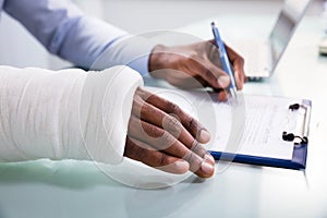 Injured Man Filling Insurance Claim Form