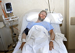 Injured man lying in bed hospital room resting from pain looking in bad health condition