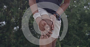 Injured man with a sore knee from exercise and fitness overexertion during a workout outside. Closeup of an