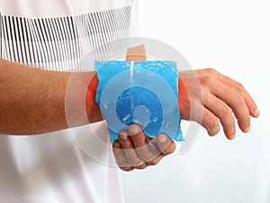 Injured Man using reusable ice gel packs his wrist, medical first aid after accident.