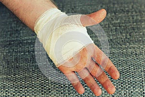 Injured painful hand with white gauze bandage