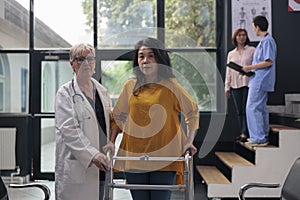 Injured patient with leg injury walking with walk frame