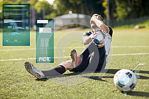 Injured soccer player with ball on football field