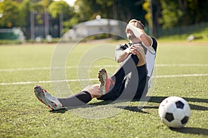 Injured soccer player with ball on football field photo