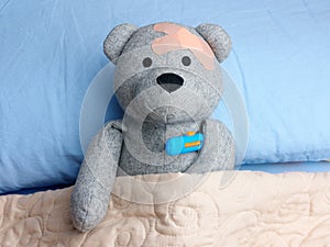 Injured Teddy Bear plasters head bed thermometer flu photo