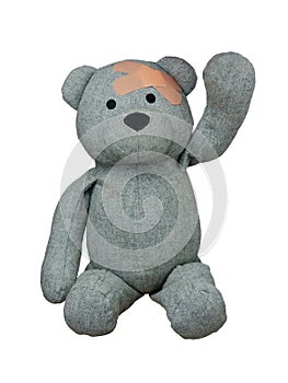 Injured Teddy Bear with plasters on head greetings hand up isolated photo