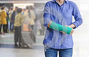 Injured woman with green cast on hand and arm on motion blur in