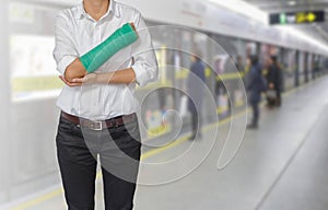 Injured woman with green cast on hand and arm on motion blur in