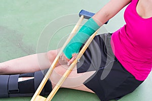 Injured woman wearing sportswear painful arm with gauze bandage
