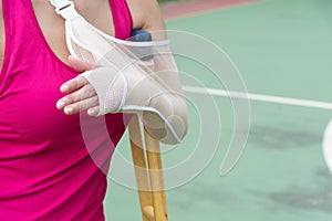 Injured woman wearing sportswear painful arm with gauze bandage