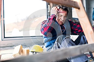 Injured worker with wound on head, head injury. Work injury, accident in workplace.