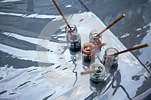 Ink colors in clear glass bottles on dark table with clear plastic cover