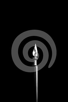 an ink pen with a metal tip close-up on a black background. classic fountain pen isolated macro black and white. copy