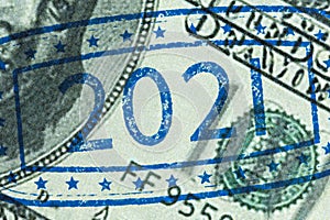 Ink stamp 2021 on hundred dollar bill