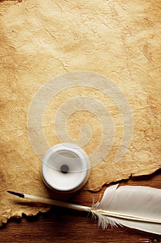 Inkwell and feather on a old paper