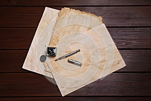 Inkwell, fountain pen and vintage parchment on table, flat lay