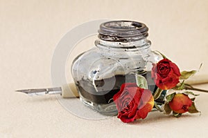 Inkwell, pen and dried roses on vintage paper background. Love letters idea