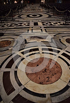 Inlaid floor of the cathedral of Santa Maria in Fiore in Florence, with a large circle in the foreground and others further away.