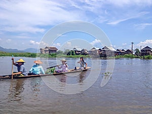 INLE LAKE, MYANMAR - MAY 26, 2014 : Local people are on longtail boat in front of Floating village at Inle Lake