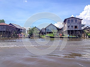 INLE LAKE, MYANMAR - MAY 26, 2014 : Local people are on longtail boat in front of Floating village at Inle Lake