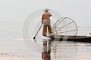 Inle, Myanmar - March 2019: Traditional Burmese leg rowing fisherman at Inle lake