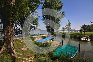 Inlet of a river with docked boats in a park in the italian countryside