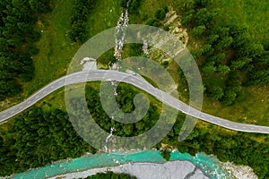 Inn River flowing in the forest in Switzerland. Aerial view from drone on a blue river in the mountains