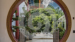 The inner courtyard of the Kek Lok Si Temple is visible through a rounded doorway. photo