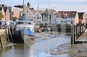 Inner harbor at low tide in the old town of Husum with boats on photo