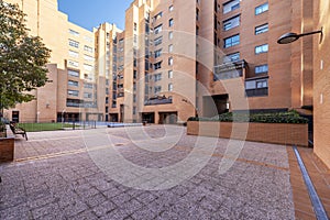 Inner patio of an urbanization with swimming pool, wooden benches and gardens