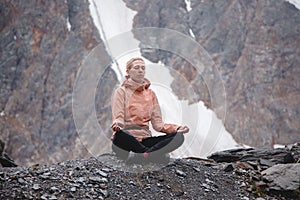 Inner peace and care. A woman meditates with a beautiful view of the snow-capped mountains. Aktru Glacier Highlands