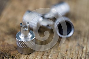 Inner tube valve on a wooden workshop table. Accessories for vulcanizer for repairing inner tubes and car tires.